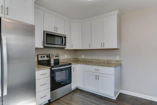 kitchen featuring white cabinets, light stone counters, stainless steel appliances, and dark wood-type flooring