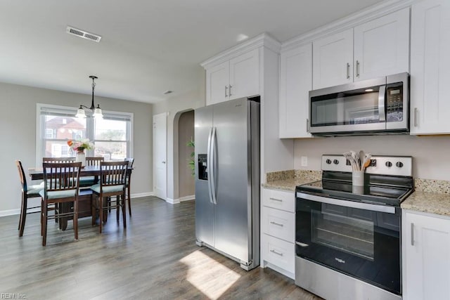 kitchen featuring stainless steel appliances, arched walkways, white cabinets, and visible vents