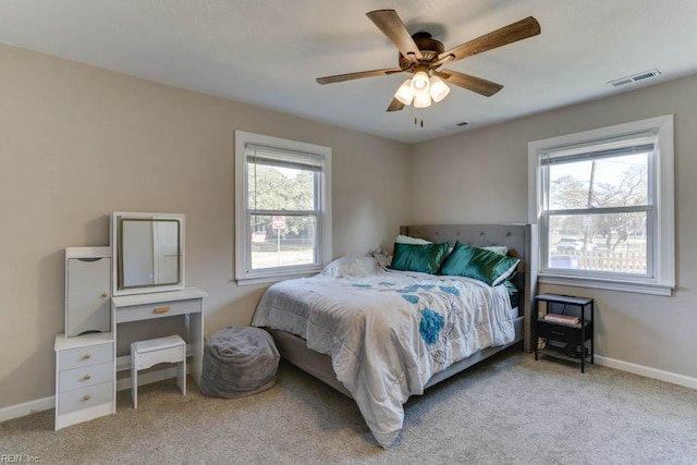 carpeted bedroom with visible vents, ceiling fan, baseboards, and multiple windows