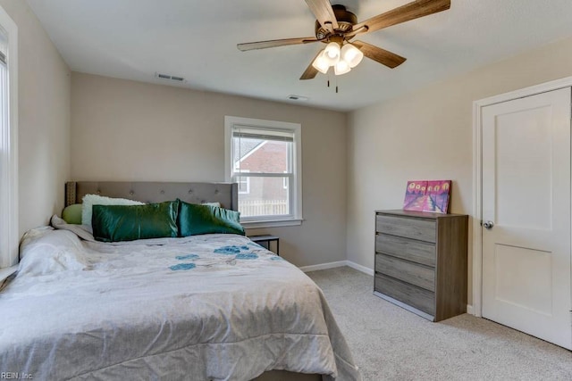 bedroom featuring light colored carpet, visible vents, ceiling fan, and baseboards