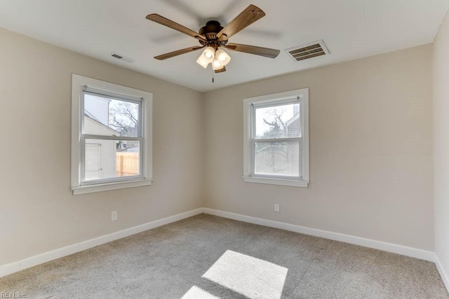 unfurnished room with baseboards, visible vents, and a wealth of natural light