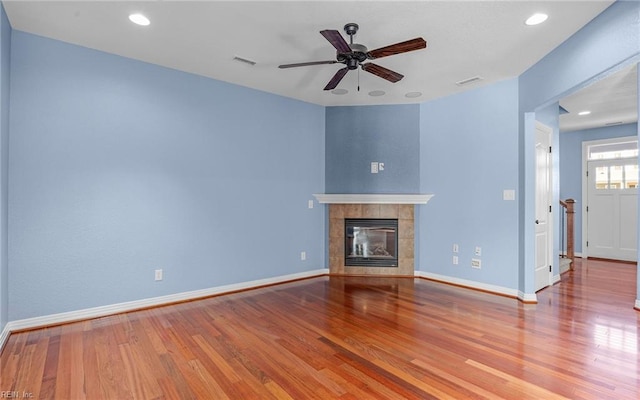 unfurnished living room featuring a fireplace, wood finished floors, visible vents, and baseboards