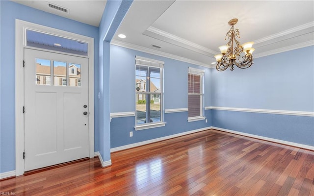 entrance foyer with ornamental molding, baseboards, visible vents, and hardwood / wood-style floors