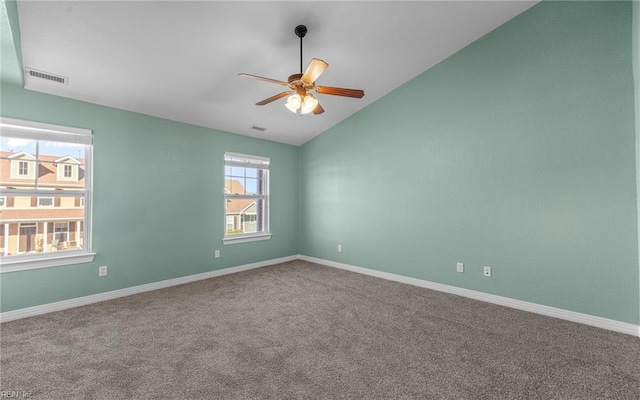 carpeted spare room featuring ceiling fan, lofted ceiling, visible vents, and baseboards