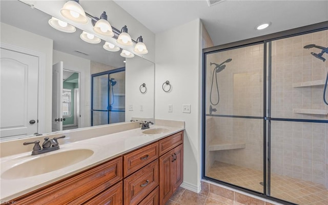 full bath featuring double vanity, tile patterned floors, a sink, and a shower stall