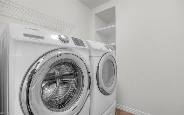 laundry area with laundry area, independent washer and dryer, and baseboards