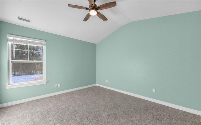 empty room with carpet, visible vents, vaulted ceiling, ceiling fan, and baseboards