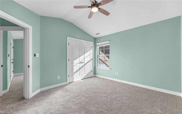 unfurnished bedroom featuring carpet floors, lofted ceiling, visible vents, and baseboards