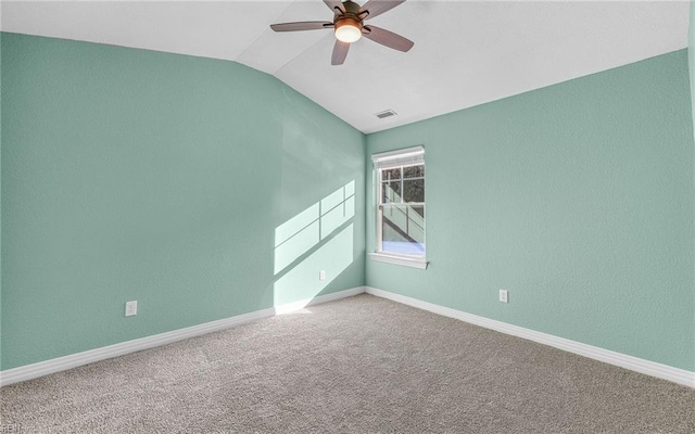 spare room with carpet floors, vaulted ceiling, baseboards, and ceiling fan