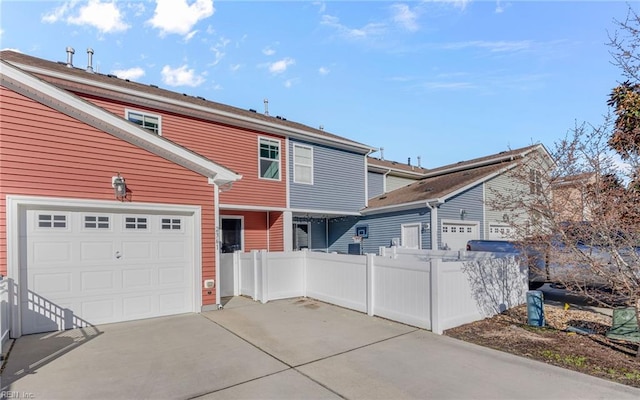 view of front of house featuring fence, driveway, and an attached garage