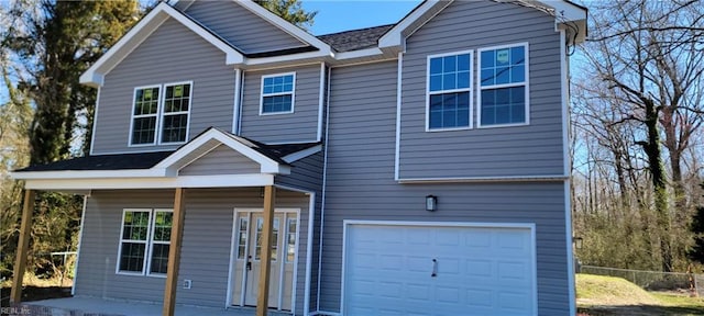 view of front of home with an attached garage and fence