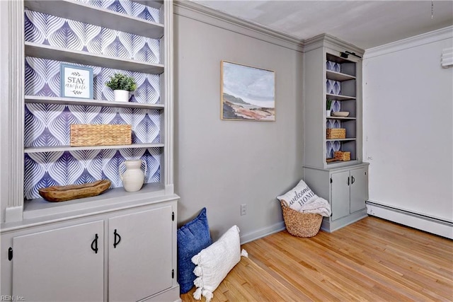 interior space with a baseboard heating unit, ornamental molding, and wood finished floors