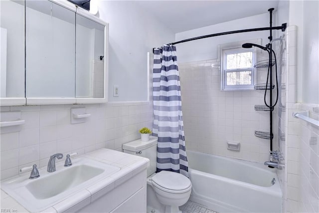 bathroom with toilet, a wainscoted wall, shower / bathtub combination with curtain, vanity, and tile walls