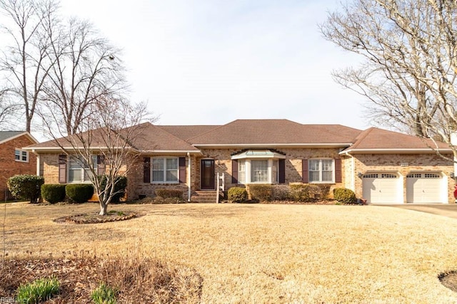 ranch-style home with a garage, driveway, brick siding, and a front yard