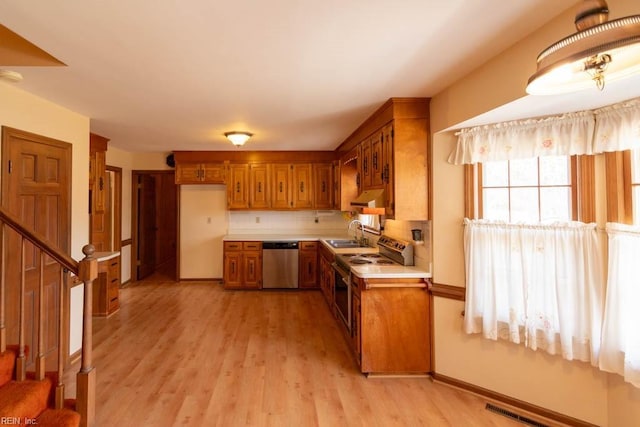 kitchen with visible vents, electric stove, brown cabinets, stainless steel dishwasher, and a sink