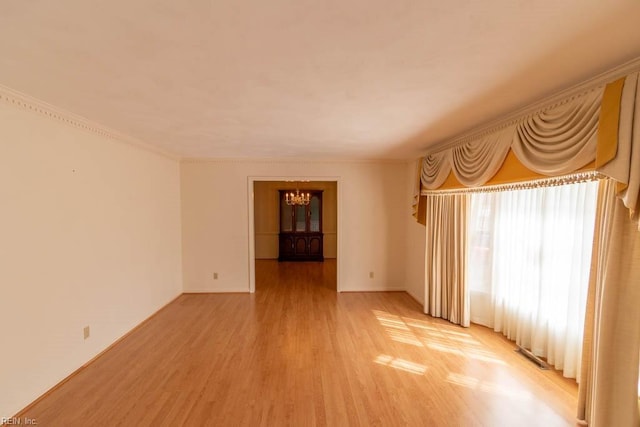 spare room featuring light wood-type flooring, visible vents, and ornamental molding