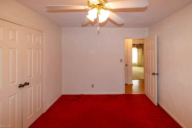 unfurnished bedroom with ceiling fan, a closet, carpet flooring, and baseboards