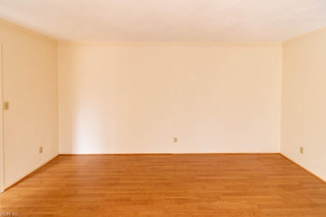 empty room featuring ornamental molding and light wood-type flooring