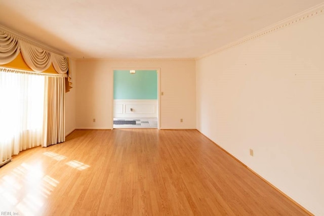 unfurnished room featuring ornamental molding and light wood-type flooring