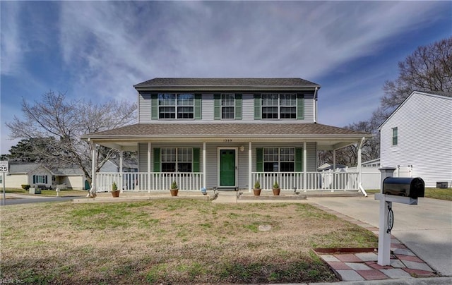 farmhouse inspired home featuring a shingled roof, a front lawn, a porch, and concrete driveway