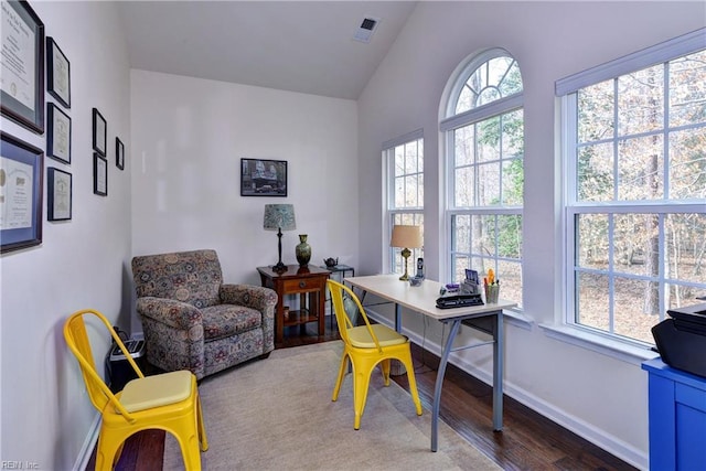 home office with baseboards, visible vents, vaulted ceiling, and wood finished floors