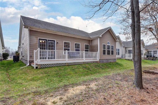 rear view of house with cooling unit, a deck, and a lawn