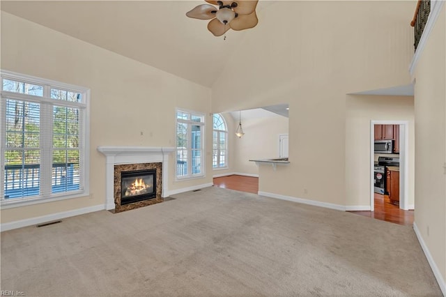 unfurnished living room featuring high vaulted ceiling, baseboards, visible vents, and carpet flooring