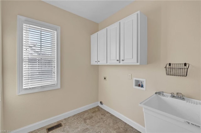 clothes washing area featuring cabinet space, plenty of natural light, visible vents, and hookup for an electric dryer