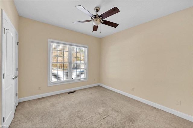 spare room featuring carpet flooring, visible vents, and baseboards