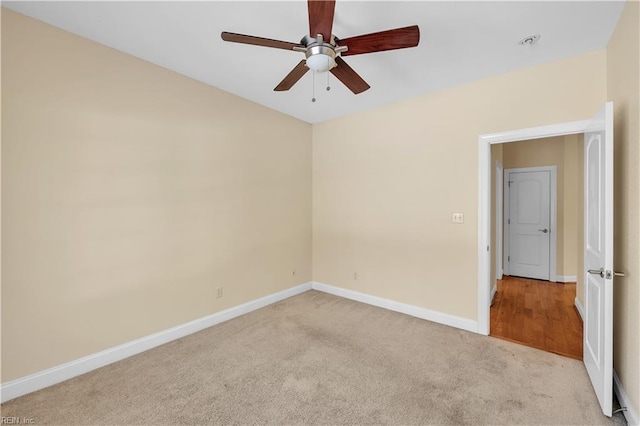 unfurnished room with baseboards, ceiling fan, and light colored carpet