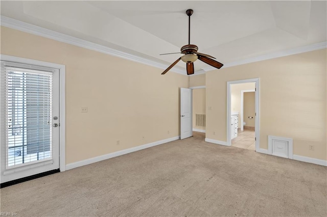 unfurnished bedroom with ornamental molding, a raised ceiling, light colored carpet, and baseboards