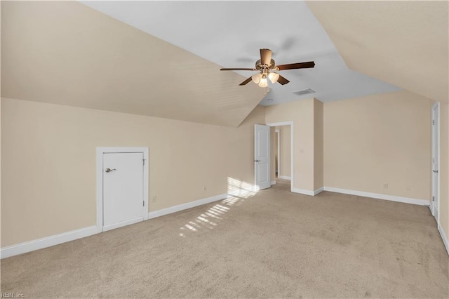 additional living space featuring lofted ceiling, visible vents, a ceiling fan, light carpet, and baseboards