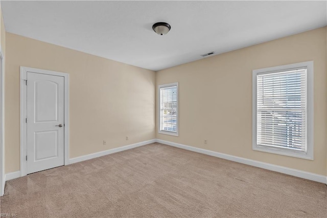 carpeted empty room with visible vents and baseboards