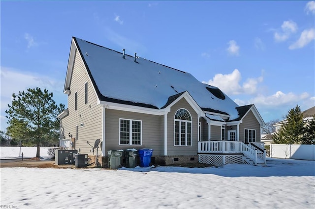 snow covered back of property featuring central AC, crawl space, and fence