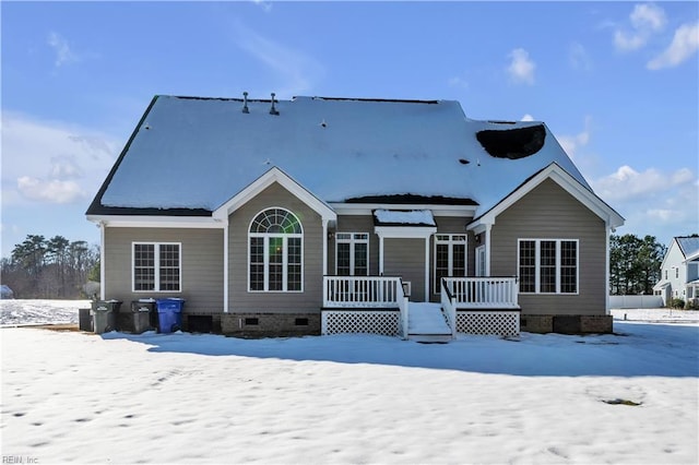 snow covered rear of property featuring crawl space and a deck