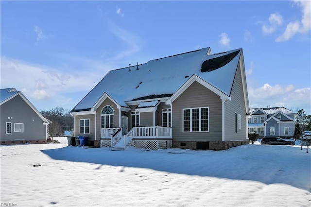 snow covered house featuring crawl space