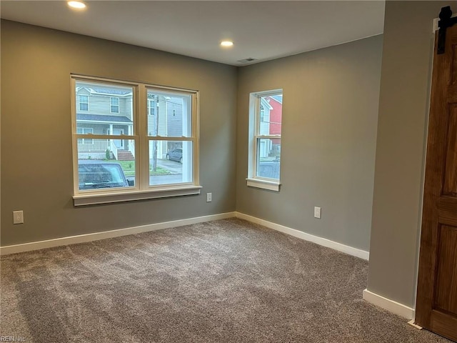 carpeted empty room with recessed lighting, visible vents, and baseboards