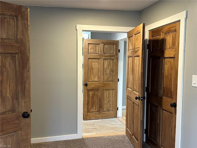 corridor featuring light carpet and baseboards