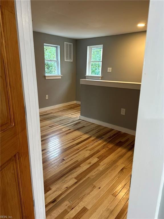 spare room with light wood-type flooring and baseboards