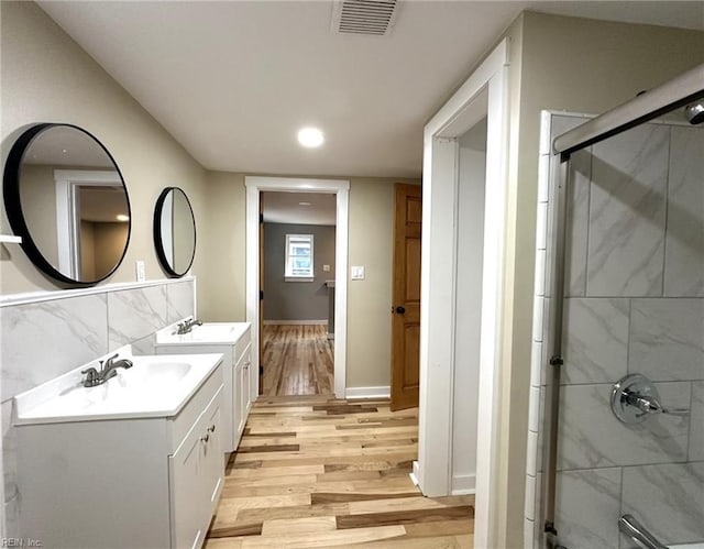 bathroom featuring visible vents, wood finished floors, vanity, a shower stall, and recessed lighting