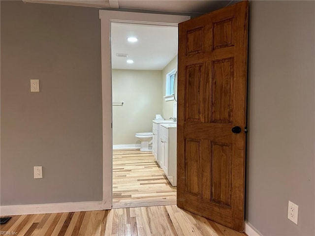 bathroom with toilet, wood finished floors, visible vents, vanity, and baseboards