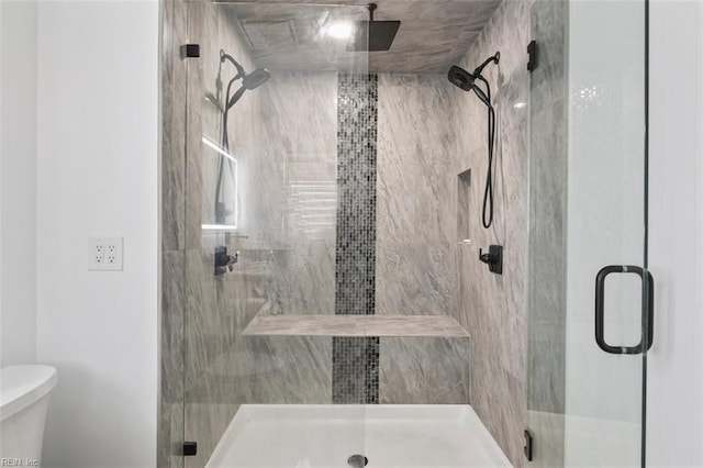 bathroom with a shower stall and toilet