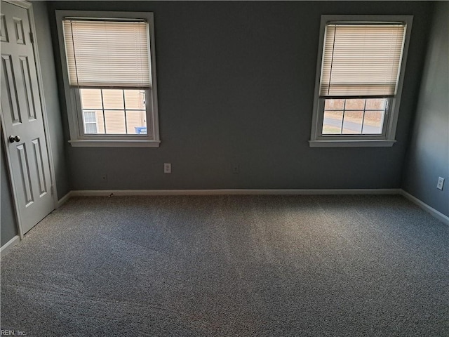 carpeted spare room with plenty of natural light and baseboards