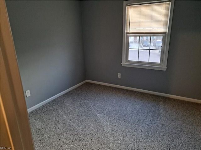 spare room featuring carpet flooring and baseboards