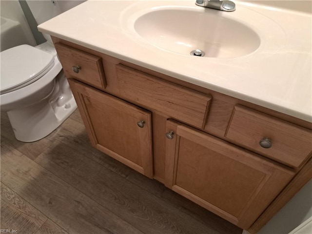 bathroom featuring toilet, wood finished floors, and vanity