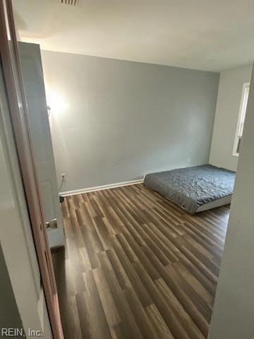 unfurnished bedroom featuring visible vents and dark wood-type flooring