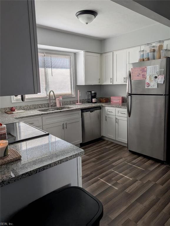 kitchen featuring a sink, appliances with stainless steel finishes, dark wood finished floors, and white cabinetry