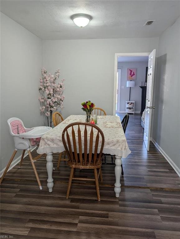 dining area with a textured ceiling, dark wood-style floors, visible vents, and baseboards