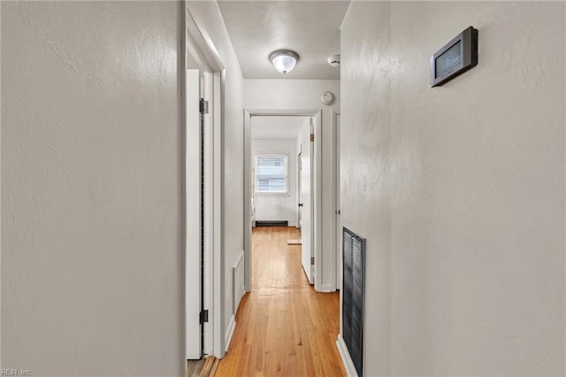 hall featuring light wood finished floors and visible vents