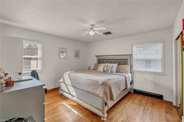 bedroom with light wood-type flooring, baseboards, visible vents, and a ceiling fan